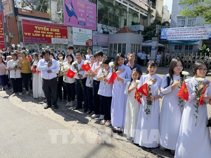 Đông đảo các tầng lớp nhân dân đứng dọc hai bên đường tiễn đưa, tưởng nhớ các Anh hùng liệt sĩ được quy tập tại Công viên Lê Thị Riêng về nơi an táng. Ảnh: Trung Tuyến - TTXVN