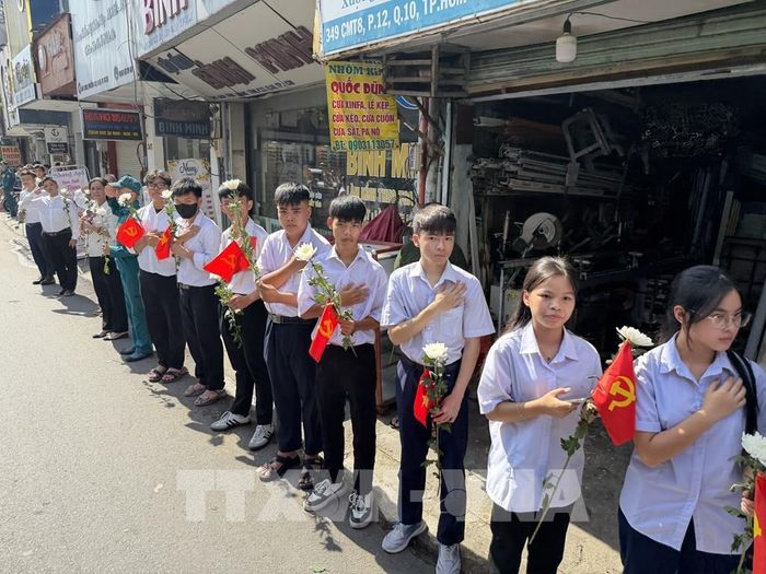 Đông đảo các tầng lớp nhân dân đứng dọc hai bên đường tiễn đưa, tưởng nhớ các Anh hùng liệt sĩ được quy tập tại Công viên Lê Thị Riêng về nơi an táng. Ảnh: Trung Tuyến - TTXVN