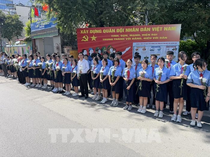 Đông đảo các tầng lớp nhân dân đứng dọc hai bên đường tiễn đưa, tưởng nhớ các Anh hùng liệt sĩ được quy tập tại Công viên Lê Thị Riêng về nơi an táng. Ảnh: Trung Tuyến - TTXVN