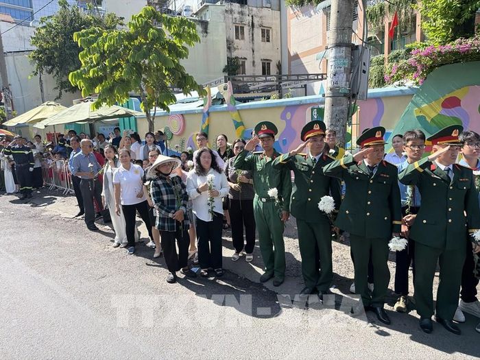 Đông đảo các tầng lớp nhân dân đứng dọc hai bên đường tiễn đưa, tưởng nhớ các Anh hùng liệt sĩ được quy tập tại Công viên Lê Thị Riêng về nơi an táng. Ảnh: Trung Tuyến - TTXVN