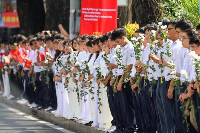 Người dân TP.HCM đứng dọc các tuyến đường nơi đoàn xe đi qua để đưa tiễn các anh hùng liệt sĩ. Ảnh: Thông Tin Chính Phủ.