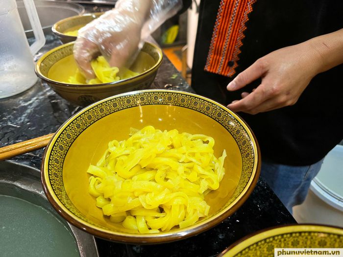 Những sợi phở ngô vàng óng, dẻo thơm, đậm hương vị ngô, được xếp đầy trong chiếc bát gốm hoa văn truyền thống.