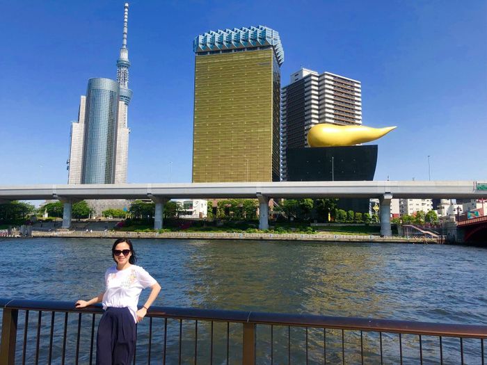 Chị Ngọc Tiếng bên dòng sông Sumida (Asakusa, Tokyo) với phía xa là tháp Tokyo Skytree và tòa nhà Asahi Beer Hall nổi tiếng. Ảnh nhân vật cung cấp