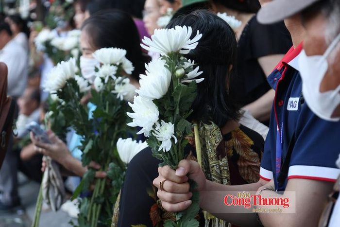 Trên tay mỗi người là những cành hoa trắng, biểu tượng của lòng thành kính trong buổi tiễn đưa các liệt sĩ về Nghĩa trang Liệt sĩ TP. Hồ Chí Minh.