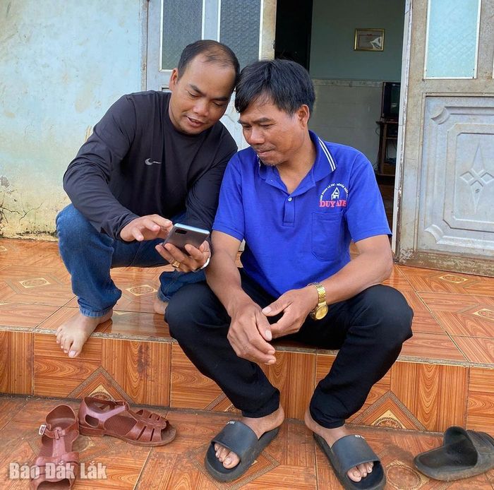 Buôn trưởng Y Bhăng Niê (bìa trái) ở buôn Tah, xã Cuôr Đăng đến tận nhà để phổ cập tri thức số cho người dân. Ảnh: Báo Đắk Lắk.