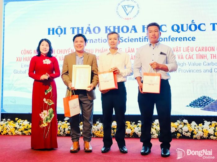 Bà Hoàng Thị Bích Hằng, Chủ tịch Liên hiệp các Hội khoa học và kỹ thuật Đồng Nai trao quà tri ân cho các giáo sư, nhà khoa học của Việt Nam và Trường đại học công nghệ Queensland (Australia). Ảnh: B.Nguyên