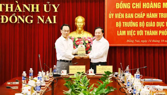 Phó Bí thư Thành ủy, Chủ tịch UBND thành phố Đồng Nai Nguyễn Văn Út trao tặng bình gốm Biên Hòa cho Ủy viên Trung ương Đảng, Bộ trưởng Bộ Giáo dục và Đào tạo Hoàng Minh Sơn. Ảnh: Công Nghĩa