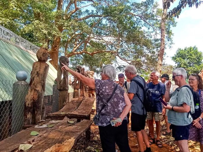  Du khách nước ngoài tìm hiểu không gian nhà mồ tại làng Kép. Ảnh: H.N 