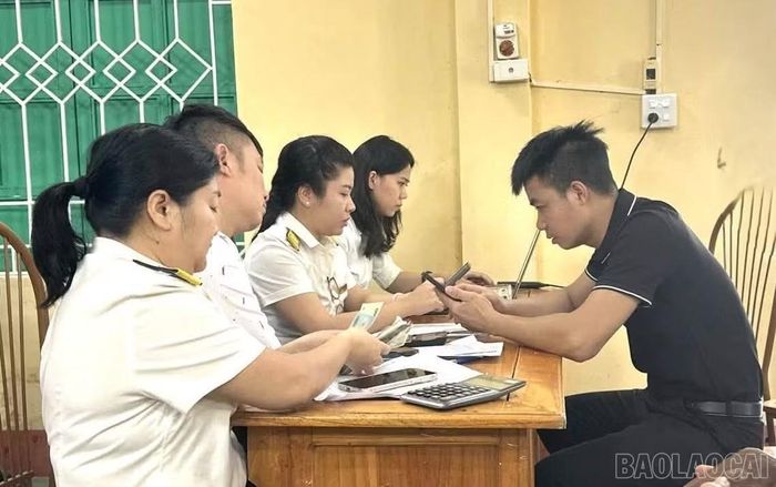 Cán bộ Thuế cơ sở 7 hướng dẫn người dân nộp thuế.