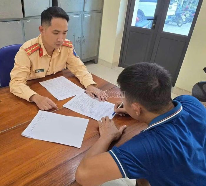 Cảnh sát giao thông làm việc với tài xế N.V.L. vi phạm quy định về thiết bị ghi nhận hình ảnh người lái xe và thẻ nhận dạng.