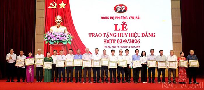 Các đồng chí trong Ban Thường vụ Đảng ủy phường Yên Bái trao Huy hiệu Đảng cho các đảng viên.