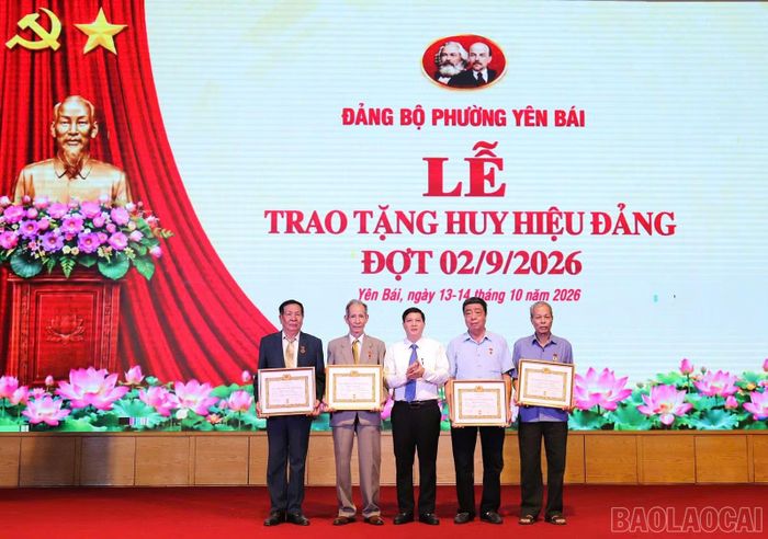 Đồng chí Nguyễn Hoàng Hà - Phó Bí thư Thường trực Đảng ủy phường Yên Bái trao tặng Huy hiệu Đảng cho các đảng viên.