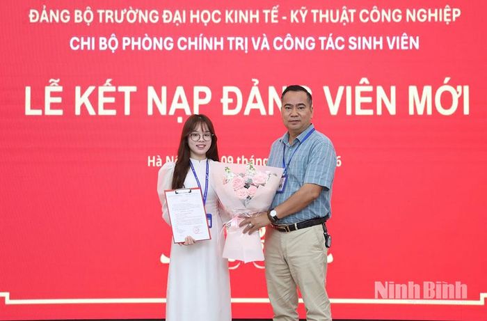 Đồng chí Bí thư Chi bộ Phòng Chính trị và Công tác sinh viên (Đảng bộ Trường Đại học Kinh tế - Kỹ thuật Công nghiệp) trao quyết định kết nạp đảng viên mới cho sinh viên. Ảnh: Nguyễn Huỳnh