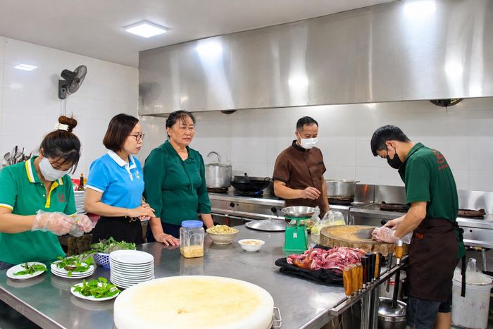 Bà Nguyễn Thị Lệ (giữa) giới thiệu với lãnh đạo Hội LHPN phường về quy trình chế biến các món ăn, bảo đảm chất lượng.