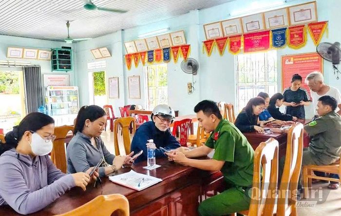 Công an phường Đồng Hới hỗ trợ người dân tích hợp tài khoản an sinh xã hội trên ứng dụng VneID - Ảnh: H.Tr