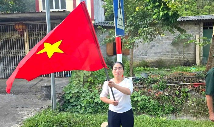 Một người dân thôn Lùng Cúng, xã Vị Xuyên vẫy cờ chào đón đoàn xe. Ảnh: Thanh Phúc