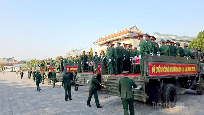 Các lực lượng chuẩn bị đưa hài cốt liệt sĩ xuống xe. Ảnh: Thanh Phúc