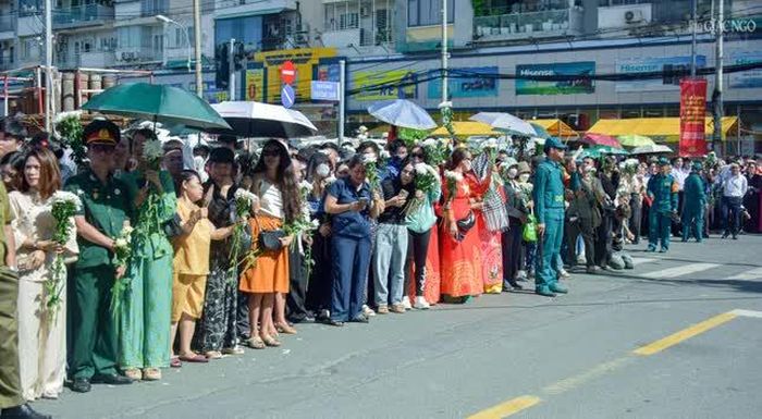 Người dân TP.HCM tay cầm nhành hoa trắng, đứng đợi dưới trời nắng nóng để tiễn đưa các anh hùng liệt sĩ
