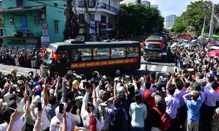 Người dân tập trung 2 bên đường tiễn đưa các anh hùng liệt sĩ về nơi an nghỉ cuối cùng tại Nghĩa trang Liệt sĩ TP.HCM - Ảnh: Gia Huy