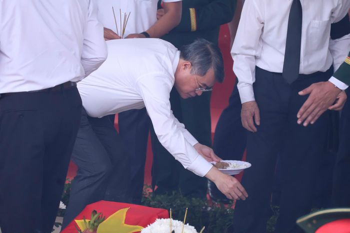 Sau nghi thức hạ huyệt, các đại biểu lần lượt dâng hương, đặt hoa, thả những nắm đất tiễn biệt các liệt sĩ. 