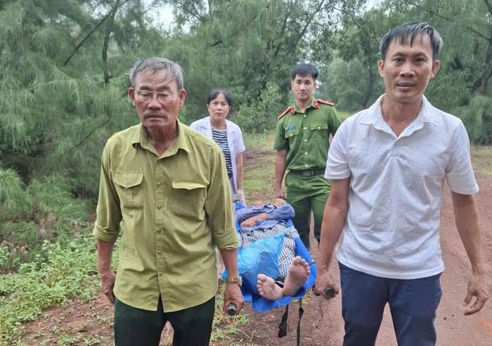 Lực lượng chức năng dùng cáng đưa anh Hà Văn S. ra khỏi khu vực rừng phòng hộ để đi cấp cứu. Ảnh Công an cung cấp
