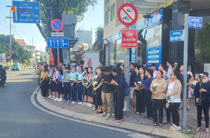 Người dân đứng tiễn đưa các Anh hùng liệt sĩ tại giao lộ Cách Mạng Tháng Tám - Điện Biên Phủ. Ảnh Nguyễn Tuấn