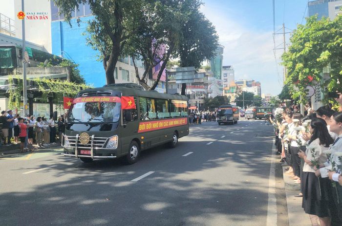 Người dân đứng trang nghiêm hai bên đường Điện Biên Phủ khi đoàn xe trở hài cốt các Anh hùng liệt sĩ đi qua. Ảnh Nguyễn Tuấn