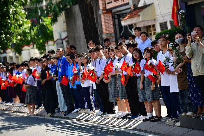 Các em học sinh trên tay cờ đỏ sao vàng và hoa cúc trắng để tiễn đưa Anh hùng liệt sĩ về nơi an nghỉ.