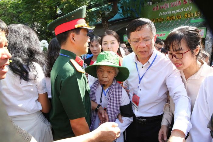 Lực lượng chức năng hỗ trợ bà Nguyễn Thị Lệ, vợ của Liệt sĩ Huỳnh Văn Quên tại buổi lễ.