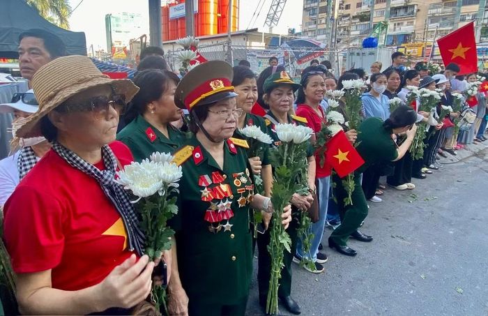 Người dân trang nghiêm chờ đoàn xe đưa hài cốt liệt sĩ về nơi an nghỉ.