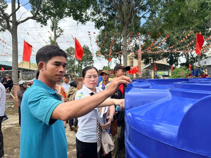Người dân có hoàn cảnh khó khăn vui mừng khi được trao tặng bồn chứa nước.