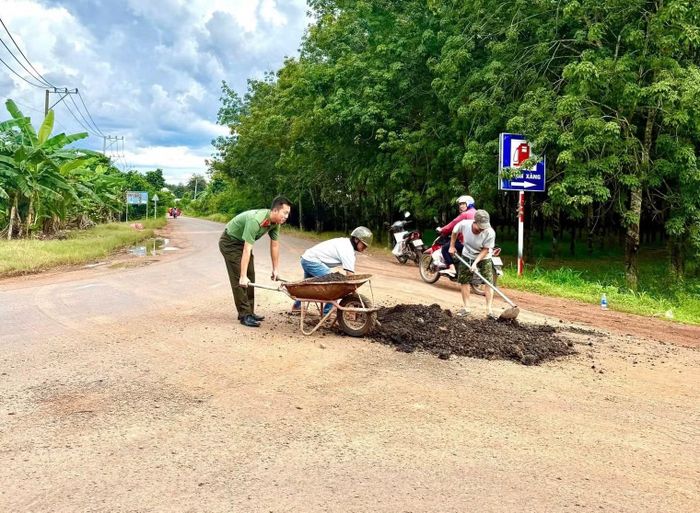 Công an xã Tân Lợi cùng người dân vá ổ gà, sửa chữa đoạn đường xấu.