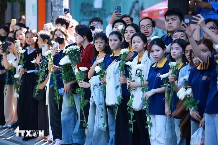 Đông đảo nhân dân thành phố Hồ Chí Minh với nhành hoa trắng trên tay đưa tiễn hài cốt các Anh hùng liệt sĩ về Nghĩa trang thành phố Hồ Chí Minh. Ảnh: TTXVN