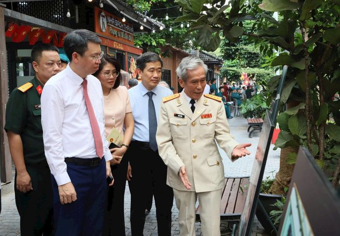 Nhà báo, Đại tá Trần Hồng giới thiệu với các đại biểu thăm quan triển lãm ảnh về đề tài LLVT Thủ đô. Ảnh: PV