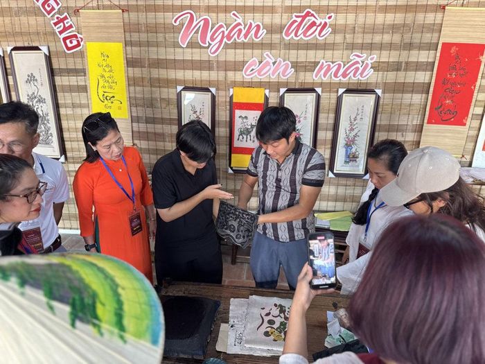 Du khách trải nghiệm làm tranh Đông Hồ. Ảnh: Hoàng Lân