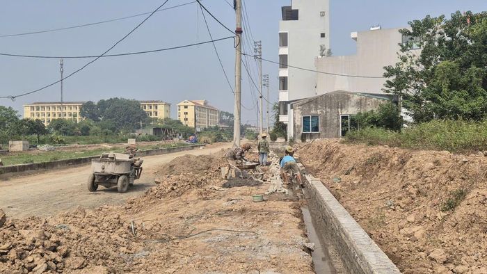 Các nhóm thợ đang thi công hệ thống thoát nước, hào kỹ thuật dọc tuyến đường. Ảnh: HL