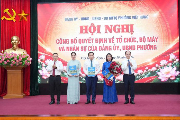 Lãnh đạo phường Việt Hưng trao quyết định, tặng hoa chúc mừng Văn phòng HĐND và UBND phường. Ảnh: PV