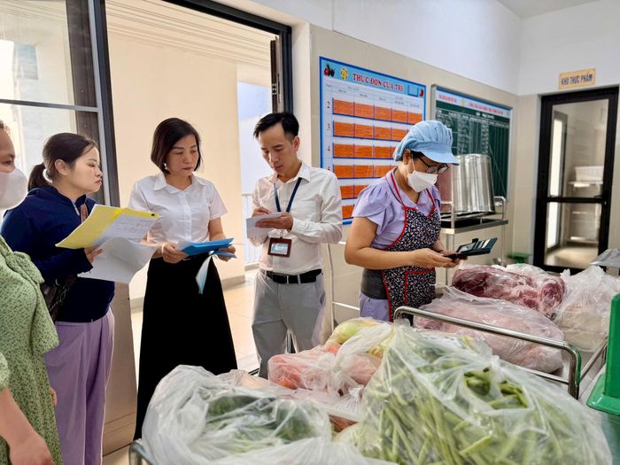 Đoàn kiểm tra liên ngành số 2 của thành phố kiểm tra số lượng thức ăn cung cấp vào bếp ăn tập thể tại Trường Mầm non Phúc Lợi. Ảnh: Ngọc Quỳnh