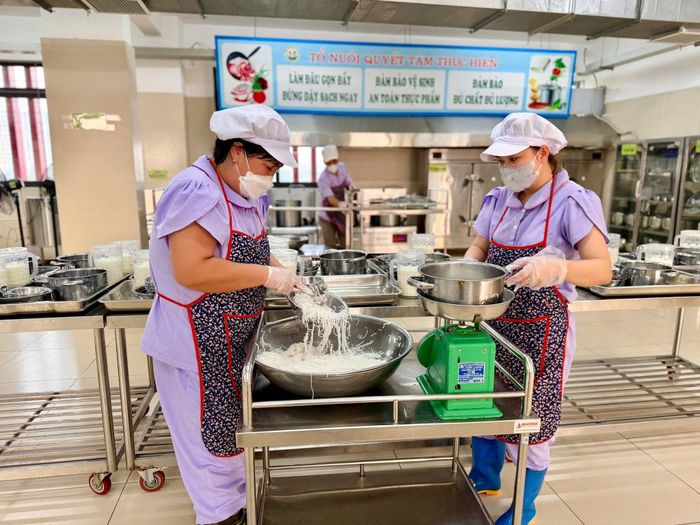 Nhân viên chuẩn bị suất ăn cho các em học sinh buổi sáng 14-10 tại Trường Mầm non Phúc Lợi. Ảnh: Ngọc Quỳnh