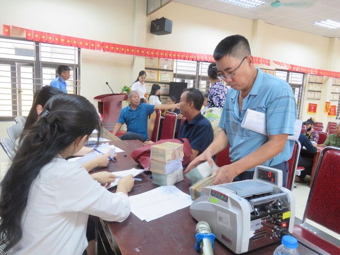 Người dân nhận tiền bồi thường GPMB. Ảnh: PV