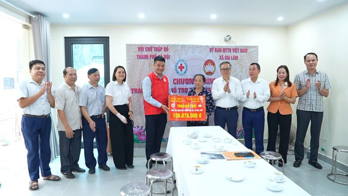 Đại diện Hội Chữ thập đỏ thành phố Hà Nội và lãnh đạo xã Gia Lâm trao kinh phí hỗ trợ xây dựng nhà Đại đoàn kết cho gia đình ông Vũ Thái Được. Ảnh: Hoàng Anh