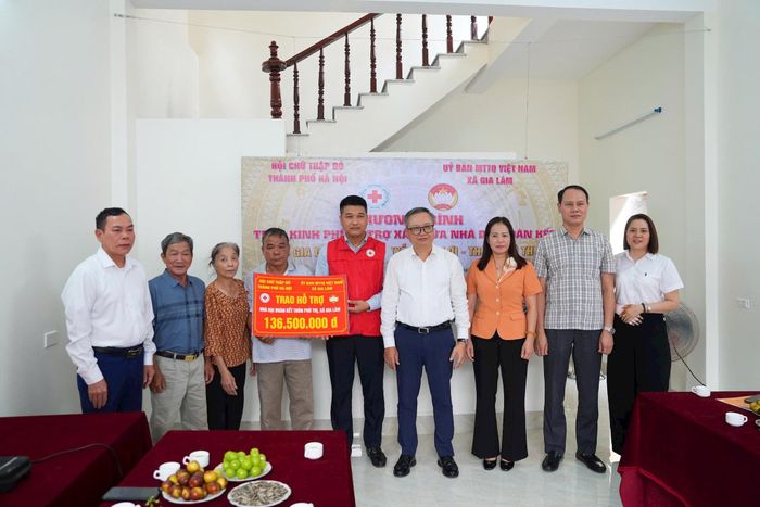 Đại diện Hội Chữ thập đỏ thành phố Hà Nội và lãnh đạo xã Gia Lâm trao kinh phí hỗ trợ xây dựng nhà Đại đoàn kết cho gia đình ông Nguyễn Văn Lợi. Ảnh: Hoàng Anh