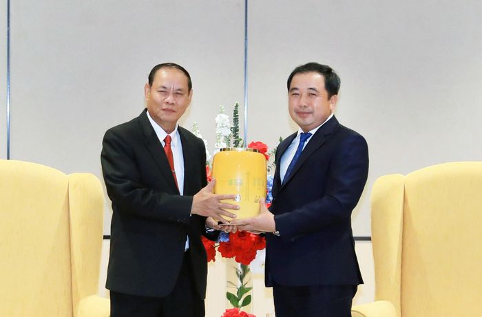 Bí thư Thành ủy Trần Đức Thắng (phải) trao quà lưu niệm của Thủ đô Hà Nội cho Đoàn đại biểu cấp cao Đảng Nhân dân Cách mạng Lào. Ảnh: Quang Thái