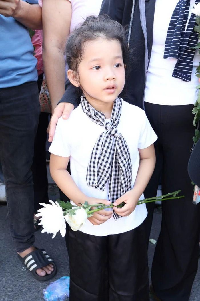 Bá gái hơn 4 tuổi cũng đang chờ đoàn xe để tiễn biệt các anh hùng liệt sĩ. Ảnh: Thùy Dương