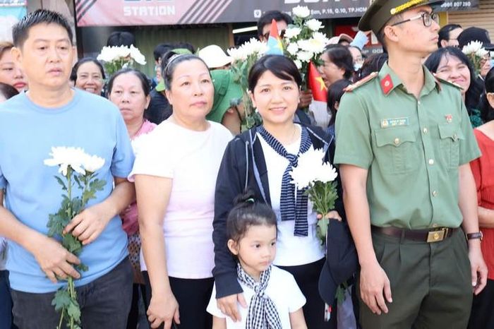 Nhiều bà mẹ đưa con đến tiễn đưa các anh hùng liệt sĩ. Ảnh: Thùy Dương