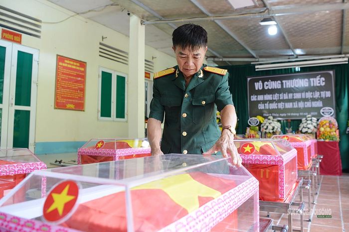 Cựu chiến binh Trịnh Xuân Hùng thành kính bên hài cốt liệt sĩ trước giờ tiễn đưa. Ảnh: Tuấn Anh
