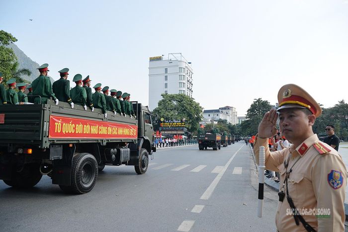 Chiến sĩ Cảnh sát giao thông chào đoàn xe đưa 93 hài cốt liệt sĩ về nghĩa trang. Ảnh: Tuấn Anh