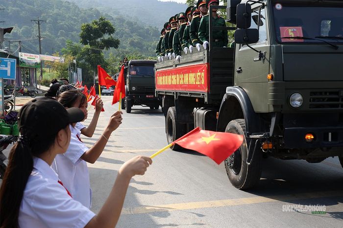 Học sinh Trường THPT Phương Tiến, xã Thanh Thủy, vẫy cờ tiễn đưa các liệt sĩ. Ảnh: Tuấn Anh