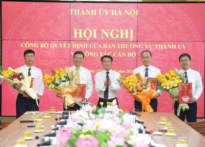 Phó Bí thư Thường trực Thành ủy Hà Nội Nguyễn Trọng Đông trao quyết định và tặng hoa chúc mừng các đồng chí nhận nhiệm vụ mới