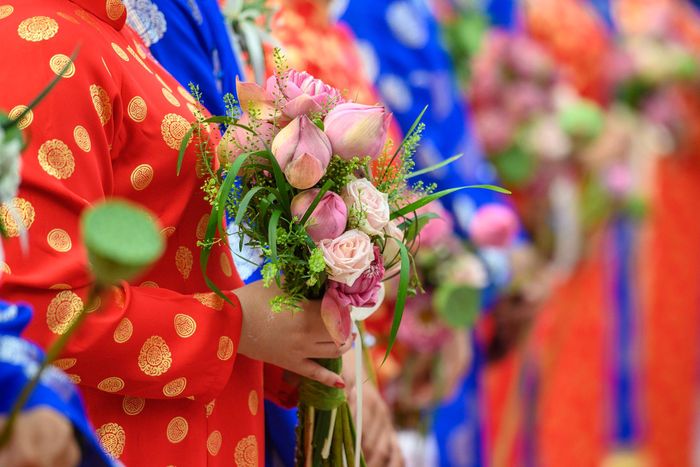 Bó hoa sen hồng cầm tay cô dâu mang ý nghĩa về tình yêu dịu dàng, sự thuần khiết và lòng thủy chung. Sắc hồng tượng trưng cho tình cảm chân thành, niềm hạnh phúc và sự gắn bó của đôi lứa.